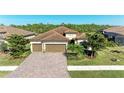 Three-car garage home with paver driveway and lush landscaping at 20710 Saluti Pl, Venice, FL 34293