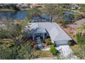 House on a lake with a screened pool and lush trees at 3267 Crystal Lakes Ct, Sarasota, FL 34235