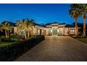 Night view of a home's exterior, highlighting its modern design and landscaping at 3407 155Th E Ave, Parrish, FL 34219