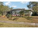 Ranch style home with a large lawn and palm trees at 349 Scott Ave, Sarasota, FL 34243