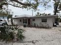 Single-story home with a red door and gravel driveway at 417 Avenida De Mayo, Sarasota, FL 34242