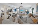 Open concept living room and kitchen with hardwood floors and breakfast bar at 4215 Gulf Of Mexico Dr # 103, Longboat Key, FL 34228