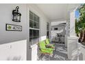 Front porch with green chairs and small table at 4755 Woodbrook Dr, Sarasota, FL 34243