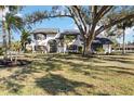 Two-story house with white exterior, dark gray accents, and a large oak tree in front at 6706 88Th E St, Bradenton, FL 34202
