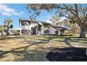 Two-story house with white exterior, dark gray accents, and a partially visible lake at 6706 88Th E St, Bradenton, FL 34202