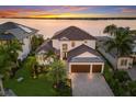 Luxury waterfront home with a two car garage and manicured landscaping at 696 Regatta Way, Bradenton, FL 34208