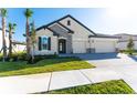 Tan house with a two-car garage and stone accents at 7228 Great Egret Blvd, Sarasota, FL 34241