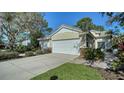 House exterior showcasing a two-car garage and a neatly landscaped front yard at 7628 Whitebridge Gln, University Park, FL 34201