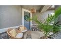 Comfortable seating, side table and a potted plant make for a cozy front porch at 10109 Milky Way Cir, Sarasota, FL 34241