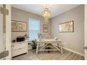 Bright home office features wood-look tile flooring and a decorative chandelier at 10109 Milky Way Cir, Sarasota, FL 34241