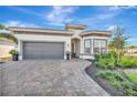 One story home with gray garage doors and a paver driveway at 10201 Beach Dune Dr, Englewood, FL 34223