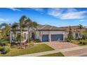 Well-maintained house featuring a gray garage door and lush landscaping at 12366 Marsh Pointe Rd, Sarasota, FL 34238