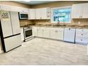 Modern kitchen with white cabinets, stainless steel appliances, and tile floors at 1414 6Th W St, Palmetto, FL 34221