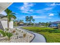 Landscaped walkway leading to a quiet neighborhood with palm trees at 1608 Honey Ct, Venice, FL 34293