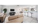 Bright living room featuring comfortable sofas and a view into kitchen at 1928 Greenlawn Dr, Englewood, FL 34223