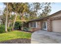 Side view of the house showing brick facade and landscaping at 1947 W Leewynn Dr, Sarasota, FL 34240