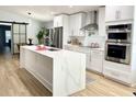 Modern white kitchen with large island, stainless steel appliances, and quartz countertops at 4029 9Th S Ave, St Petersburg, FL 33711