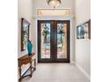 Elegant entryway with double doors, ornate glass, and wood accents at 4110 Commodore Blvd, Cortez, FL 34215