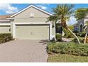 Tan house with two-car garage, palm trees, and well-manicured lawn at 4891 Maymont Park Cir, Bradenton, FL 34203