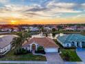 Stunning aerial view of a home near a lake at sunset at 5061 Seagrass Dr, Venice, FL 34293