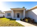 Front porch with dark brown door and walkway at 5534 Fairlane Dr, North Port, FL 34288