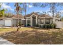 Gray house with teal front door and landscaped yard at 5574 Sweetwater Oak, Sarasota, FL 34232