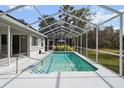 Screened-in pool area with surrounding grassy yard at 5574 Sweetwater Oak, Sarasota, FL 34232