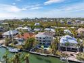 Stunning aerial view of waterfront homes, lush landscaping, private pools, and boat docks under a clear blue sky at 614 Norton St, Longboat Key, FL 34228