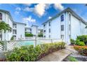 Community pool area with surrounding landscaping and building view at 6304 Pointe West Blvd # A206, Bradenton, FL 34209