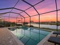 Enclosed pool and spa at sunset; stunning lake view at 6534 Clairborne Ln, Lakewood Ranch, FL 34211