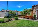 Landscaped front yard with brick walkway leading to a well-maintained home and manicured green lawn at 8279 Varenna Dr, Sarasota, FL 34231