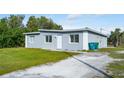 Newly constructed home showcasing a gray exterior, green lawn, and a spacious driveway at 1226 Coral Ridge Dr, Punta Gorda, FL 33950