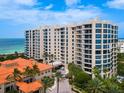 Luxury beachfront condo building with ocean views and palm trees at 1281 Gulf Of Mexico Dr # 404, Longboat Key, FL 34228