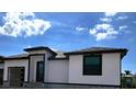 Contemporary home with dark roof, windows, and a wood-like garage door at 1327 Wesley Dr, Punta Gorda, FL 33950