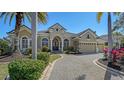 Tan house with palm trees and a large driveway at 13616 Legends Walk Ter, Lakewood Ranch, FL 34202