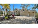 Beige house with palm trees and a large driveway at 13616 Legends Walk Ter, Lakewood Ranch, FL 34202