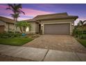 Single-story home with brown garage door and landscaped front yard at 13925 Miranese St, Venice, FL 34293