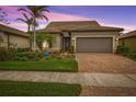 Single-story home with brown garage door and landscaped front yard at 13925 Miranese St, Venice, FL 34293