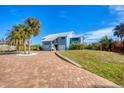 A light blue house with a metal roof and a paver driveway at 1649 Manor Rd, Englewood, FL 34223