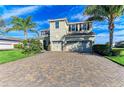 Two-story house with tile roof, three car garage, and palm trees at 16625 5Th E Ave, Bradenton, FL 34212