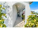 Inviting entryway with arched walkway, lush tropical plants, and a gray front door at 2302 15Th W St, Palmetto, FL 34221