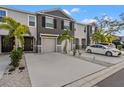 Three-unit townhome building with gray siding, two-car garages, and palm trees at 2850 Midnight Pearl Dr, Sarasota, FL 34240