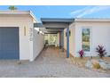 Stylish home entrance featuring a covered walkway, patterned brick path, and minimalist landscaping at 320 Avenida Leona, Sarasota, FL 34242