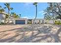 Beautiful exterior view of a home featuring a circular brick driveway, modern architectural details, and tropical landscaping at 320 Avenida Leona, Sarasota, FL 34242