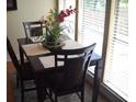 Bright dining room with a table for four, set near a large window at 3471 Clark Rd # 269, Sarasota, FL 34231