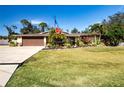 Single-story home with brown garage door, landscaping, and large yard at 4517 N Lake Dr, Sarasota, FL 34232