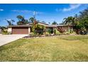 Single-story house with brown garage door and well-manicured lawn at 4517 N Lake Dr, Sarasota, FL 34232