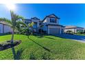 Two-story house with gray siding, tile roof, landscaping, and a paved driveway at 4852 Coastal Days Ln, Bradenton, FL 34211