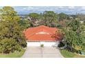 Aerial view of a house with a red tile roof and a three-car garage at 5613 Garden Lakes Dr, Bradenton, FL 34203