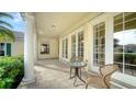 Relaxing covered patio with tile flooring, wicker chairs, and glass-top table at 5781 Girona Pl, Sarasota, FL 34238